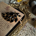 The Juliana "Prima Ballerina" brooch styled on a ballet program to emphasize its dramatic, graceful aesthetic, a perfect piece of Gothic Romance jewelry.