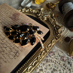 The Juliana "Prima Ballerina" brooch styled on a ballet program to emphasize its dramatic, graceful aesthetic, a perfect piece of Gothic Romance jewelry.