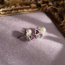 An angled view of the pearl and crystal A macro shot detailing the metallic purple rose and the warm, peachy-pink iridescence of the luminous faux pearl at the heart of this tiny masterpiece.