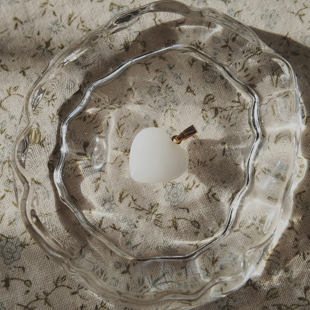 The Sun-Soaked Survivor pendant next to a ruler, illustrating its 0.9 inches petite heart length.