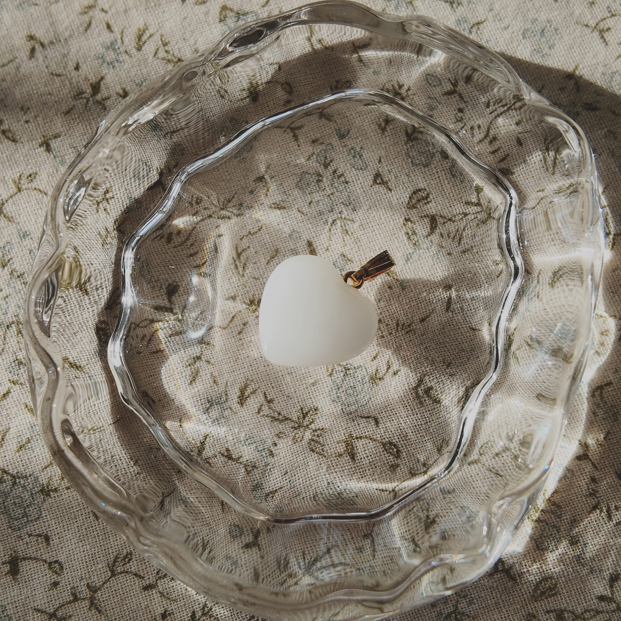 The Sun-Soaked Survivor pendant next to a ruler, illustrating its 0.9 inches petite heart length.