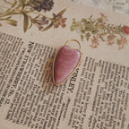 The reverse side of the upcycled Rhodochrosite charm, showcasing the clean bezel setting and the beautiful, natural banding of the stone.