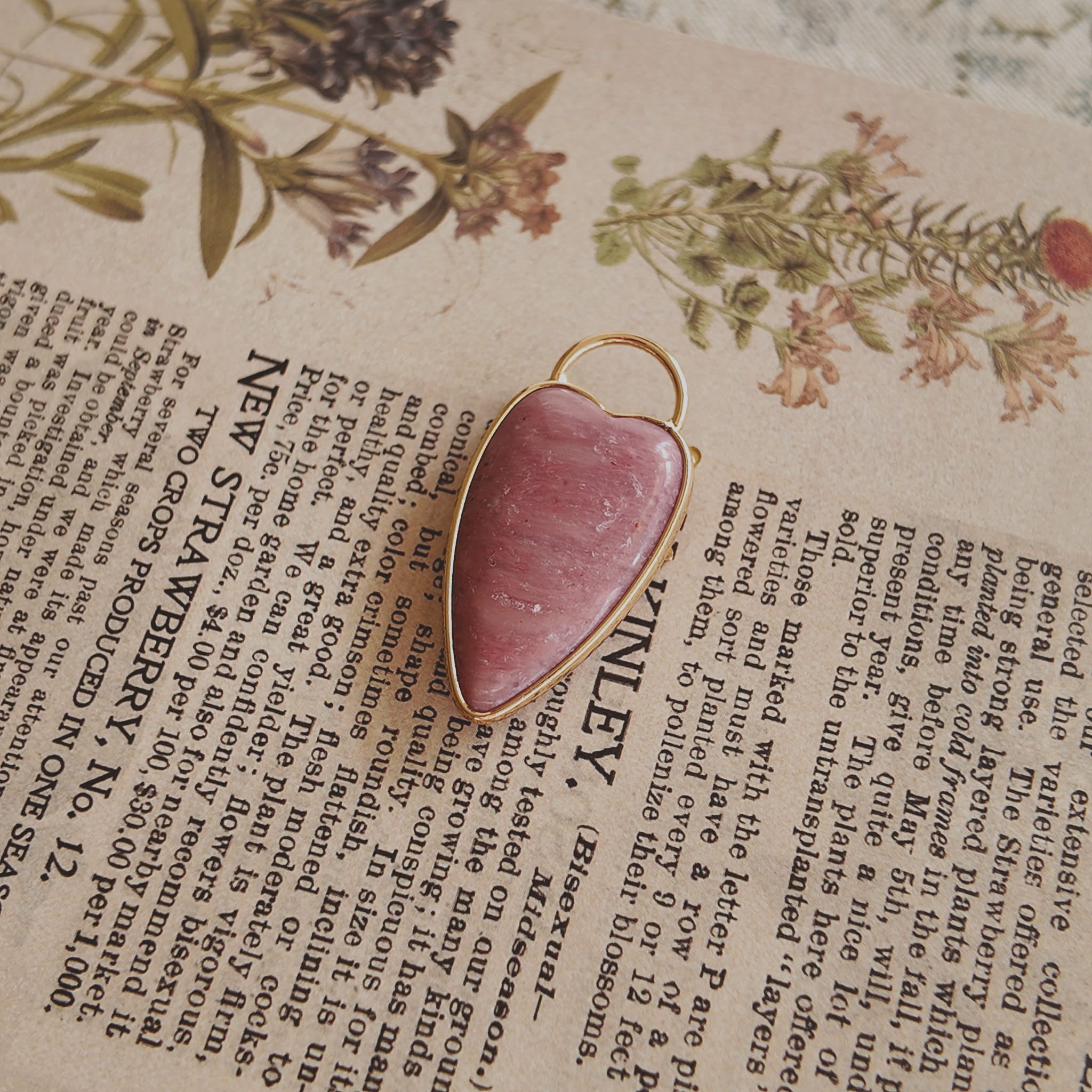 The reverse side of the upcycled Rhodochrosite charm, showcasing the clean bezel setting and the beautiful, natural banding of the stone.