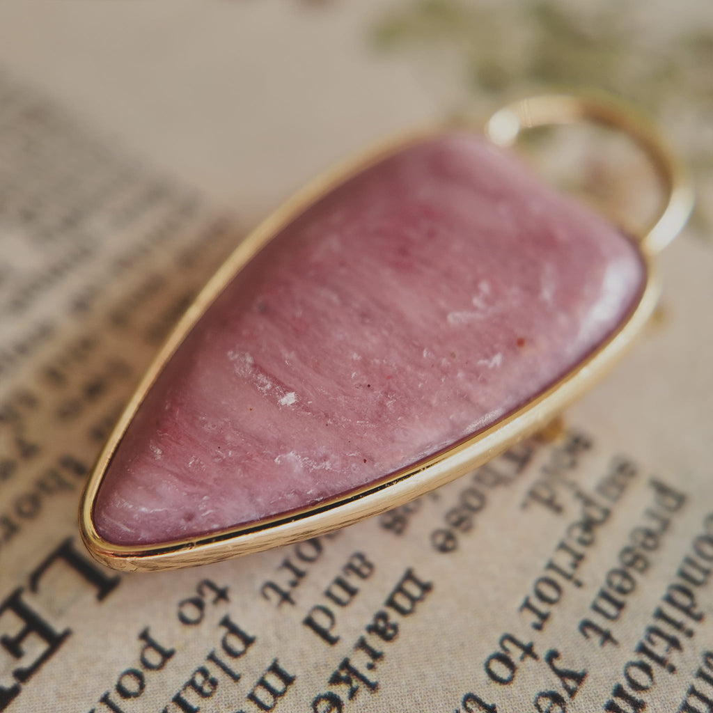 The reverse side of the upcycled Rhodochrosite charm, showcasing the clean bezel setting and the beautiful, natural banding of the stone.