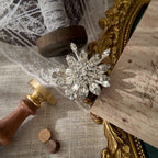 The versatile Original by Robert snowflake piece styled as a pendant on a silver chain, demonstrating its function as both a brooch and a statement necklace.