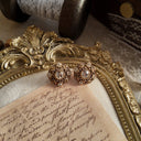 A macro shot detailing the intricate, web-like filigree work and the sparkling, hand-set quality of the crystal rhinestones on these vintage earrings.