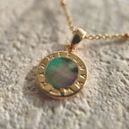 An angled view of the artisan charm, highlighting the intricate, 14k gold-plated filigree and the sparkling central cubic zirconia, with its gold-plated bail.