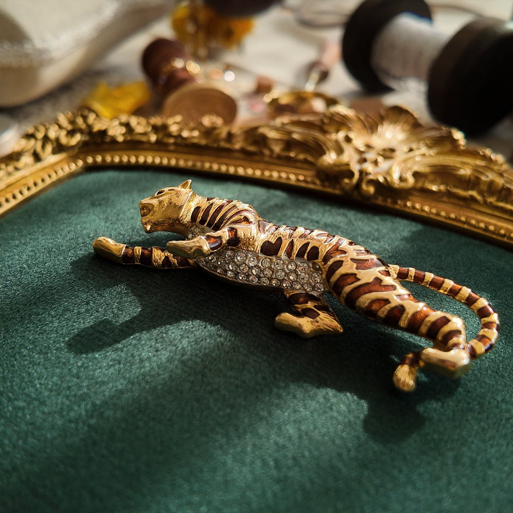 A macro shot detailing the subtle, fiery glitter within the brown enamel and the brilliant sparkle of the clear crystal rhinestones on the tiger's belly.