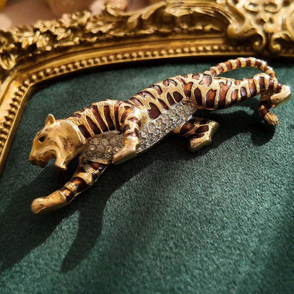 A macro shot detailing the subtle, fiery glitter within the brown enamel and the brilliant sparkle of the clear crystal rhinestones on the tiger's belly.