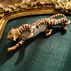 A macro shot detailing the subtle, fiery glitter within the brown enamel and the brilliant sparkle of the clear crystal rhinestones on the tiger's belly.