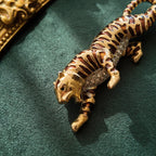 A macro shot detailing the subtle, fiery glitter within the brown enamel and the brilliant sparkle of the clear crystal rhinestones on the tiger's belly.