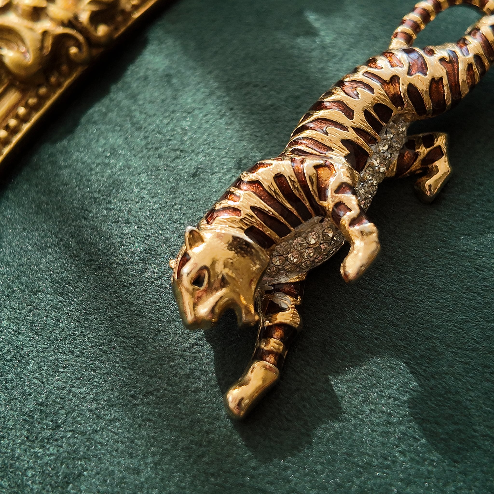 A macro shot detailing the subtle, fiery glitter within the brown enamel and the brilliant sparkle of the clear crystal rhinestones on the tiger's belly.