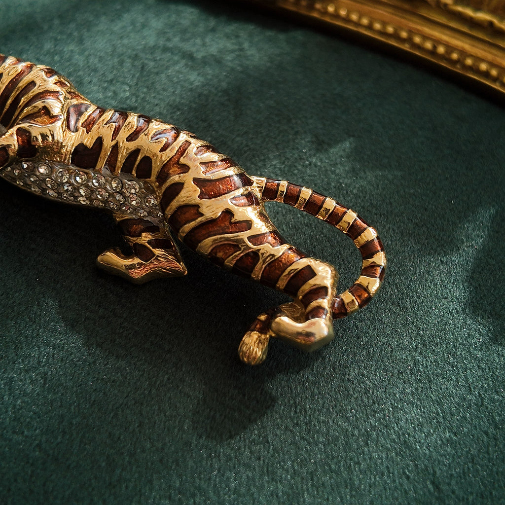 A macro shot detailing the subtle, fiery glitter within the brown enamel and the brilliant sparkle of the clear crystal rhinestones on the tiger's belly.