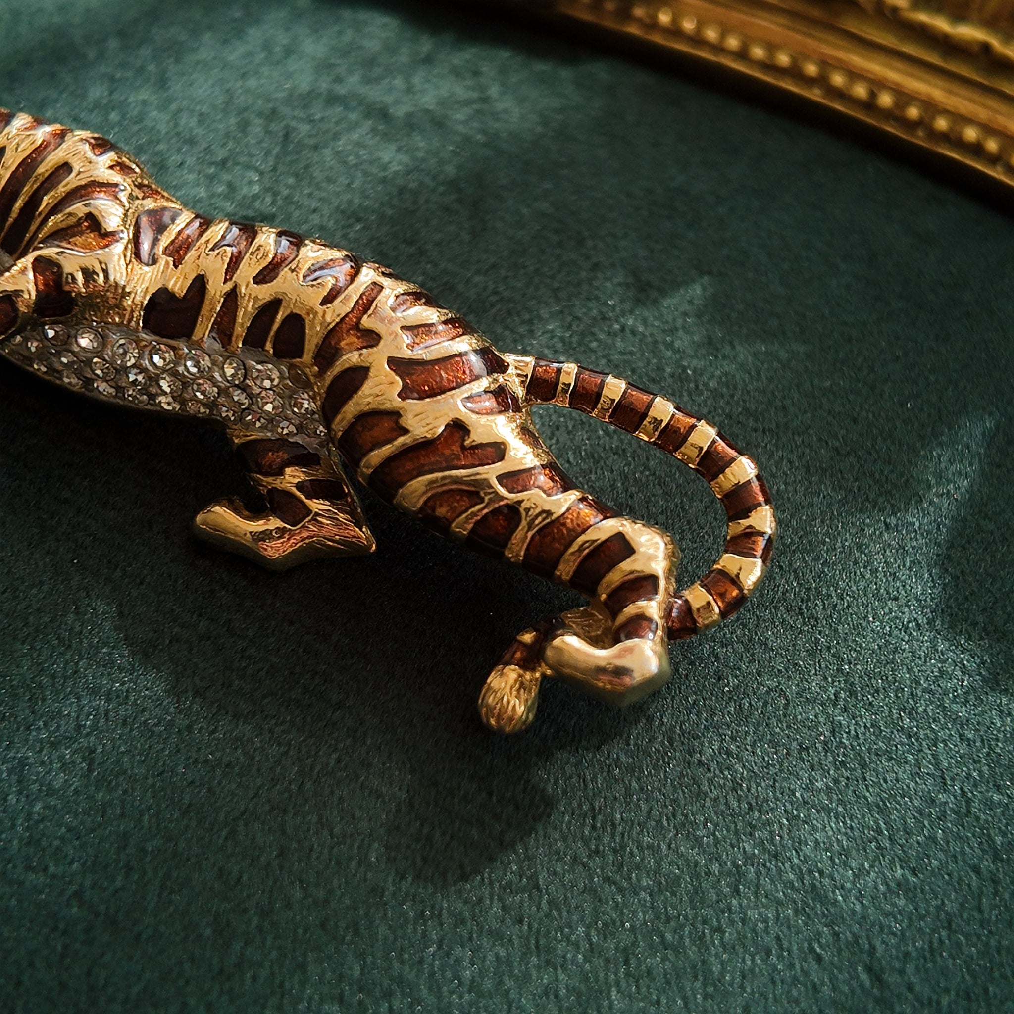 A macro shot detailing the subtle, fiery glitter within the brown enamel and the brilliant sparkle of the clear crystal rhinestones on the tiger's belly.