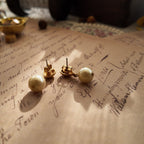 A macro shot honestly detailing the fine, hairline scratches on the gold-tone surface, a sign of this "well-loved" pair of vintage Avon earrings, sold as-is.