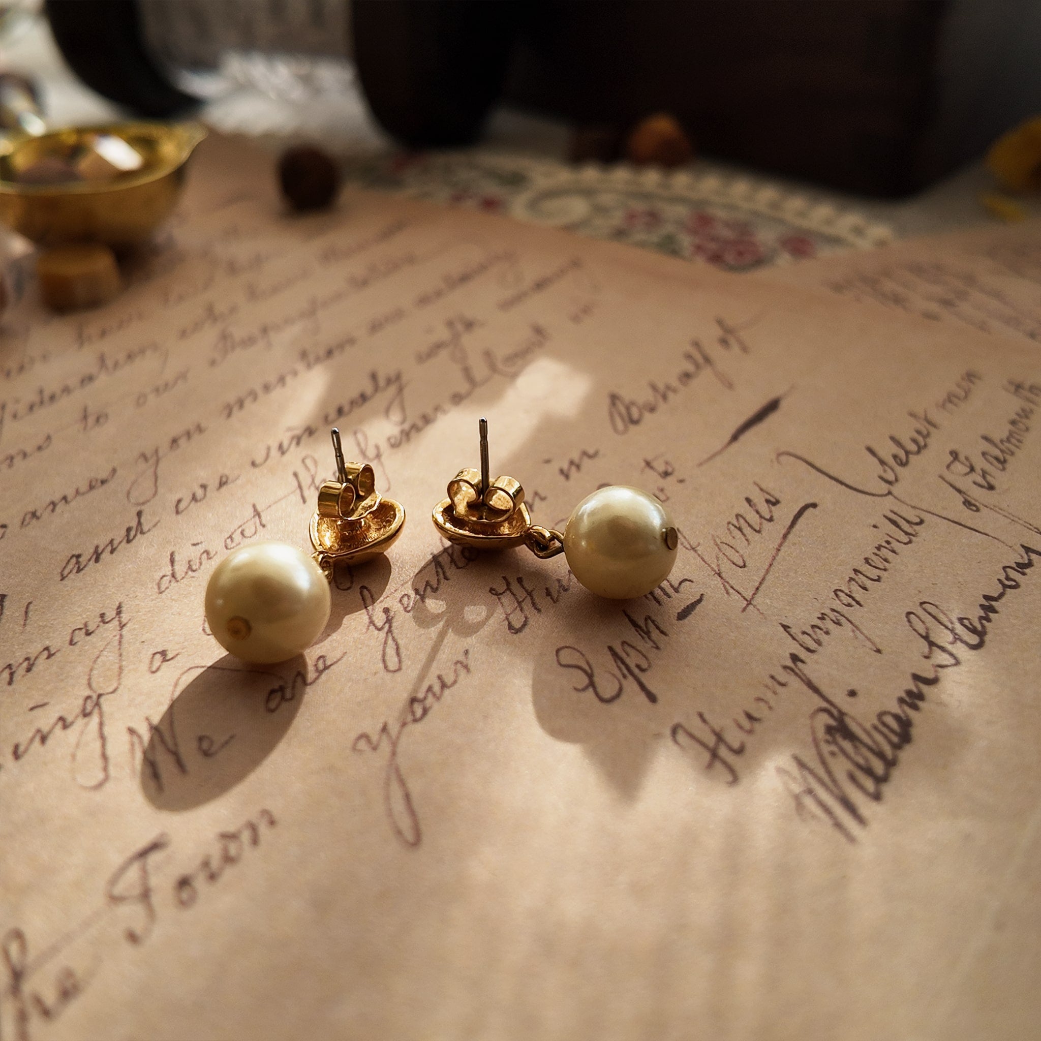 A macro shot honestly detailing the fine, hairline scratches on the gold-tone surface, a sign of this "well-loved" pair of vintage Avon earrings, sold as-is.