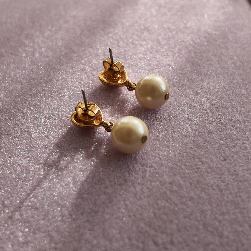 A close-up of the reverse side, showing the authentic "AVON" signature on the back of the vintage gold-plated earrings.