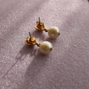 A close-up of the reverse side, showing the authentic "AVON" signature on the back of the vintage gold-plated earrings.