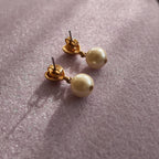 A close-up of the reverse side, showing the authentic "AVON" signature on the back of the vintage gold-plated earrings.