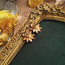 A close-up of the reverse side, showing the authentic "AVON" signature on the back of the vintage gold-plated floral stud earrings.