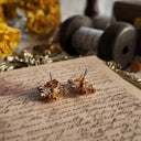 The reverse side of the earrings, showing the authentic "AVON" signature on the original clutches, confirming their excellent, collector-grade condition.