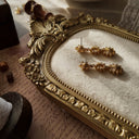 A close-up of the reverse side, showing the authentic "MONET" signature on the back of the pristine, gold-plated vintage earrings.