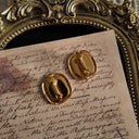 A close-up of the reverse side, showing the authentic "NAPIER" signature on the clip of the vintage gold and black square earrings.