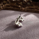 A close-up of the reverse side, showing the authentic "SAQ" signature on the clutch of the near-mint condition vintage earrings.