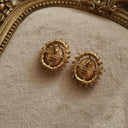 A close-up of the reverse side, showing the authentic "TRIFARI" signature with the crown logo on the back of the vintage gold-plated clip-on earrings.
