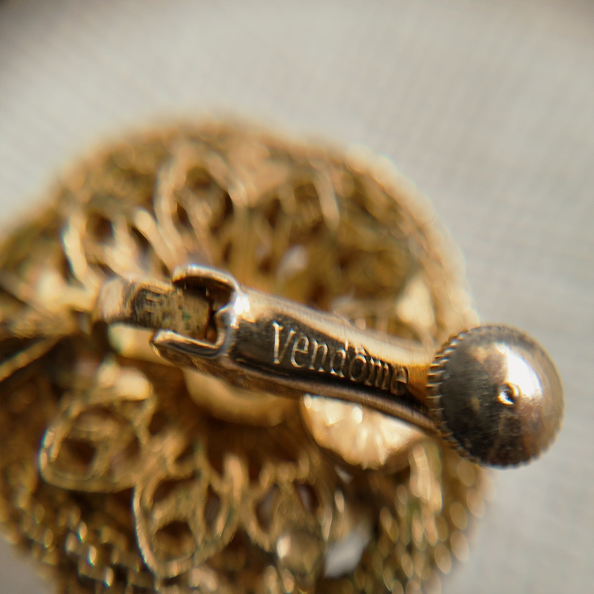 The reverse side of the brooch, showing the authentic "Vendôme" signature, as well as noticeable imperfections and wear at a connection point.