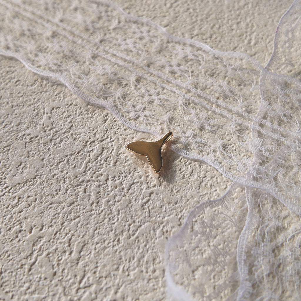 The reverse side of the "Siren's Farewell" charm, showing the smooth, polished 14k gold-plated setting and the elegant, sturdy bail.