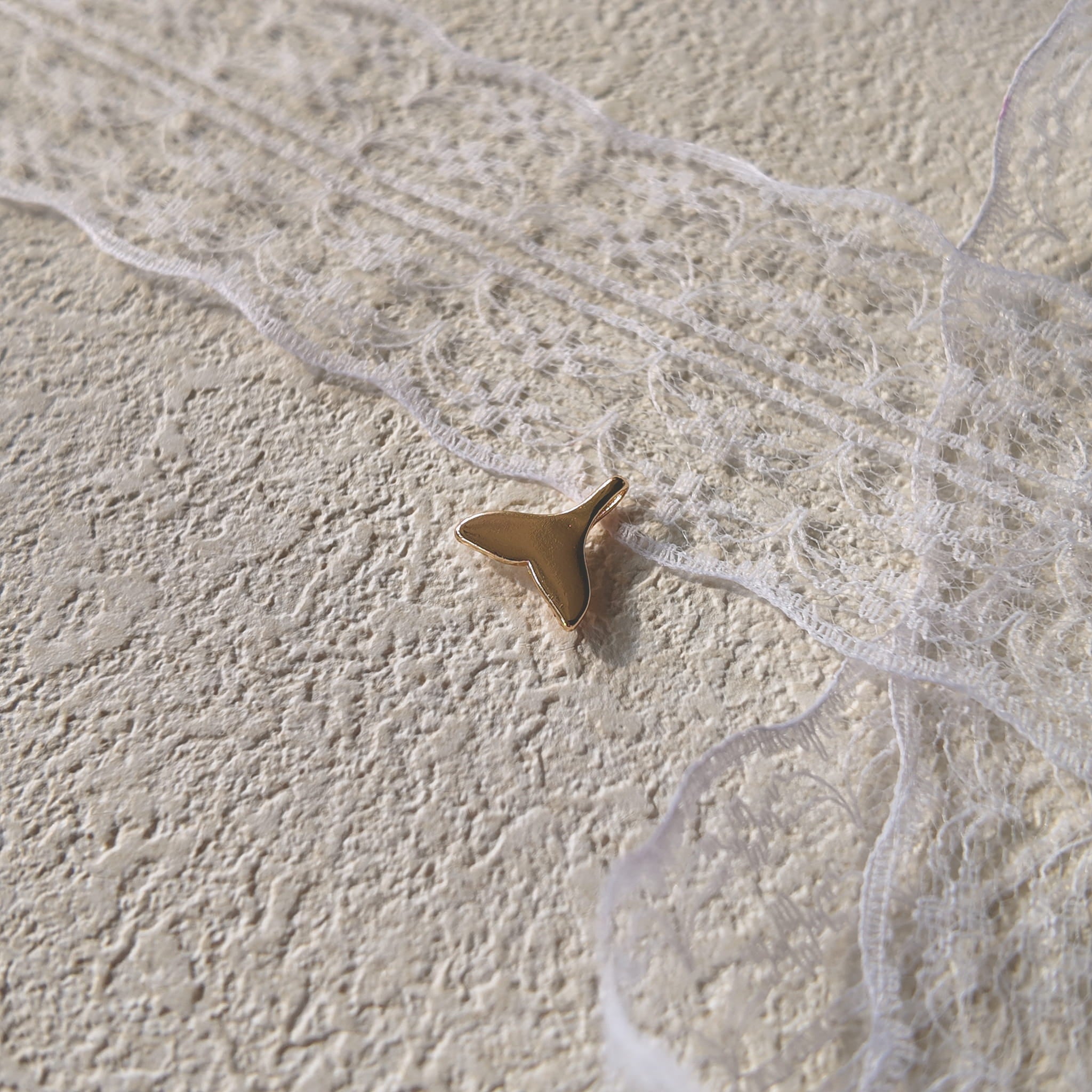 The reverse side of the "Siren's Farewell" charm, showing the smooth, polished 14k gold-plated setting and the elegant, sturdy bail.