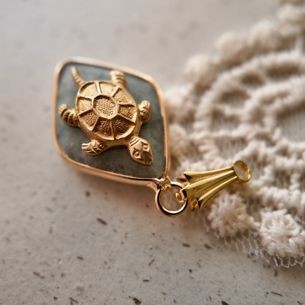 The "Ancient Navigator" turtle charm worn on a chain, showcasing its petite size and its identity as a perfect, minimalist piece of Zen jewelry.