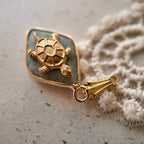The "Ancient Navigator" turtle charm worn on a chain, showcasing its petite size and its identity as a perfect, minimalist piece of Zen jewelry.