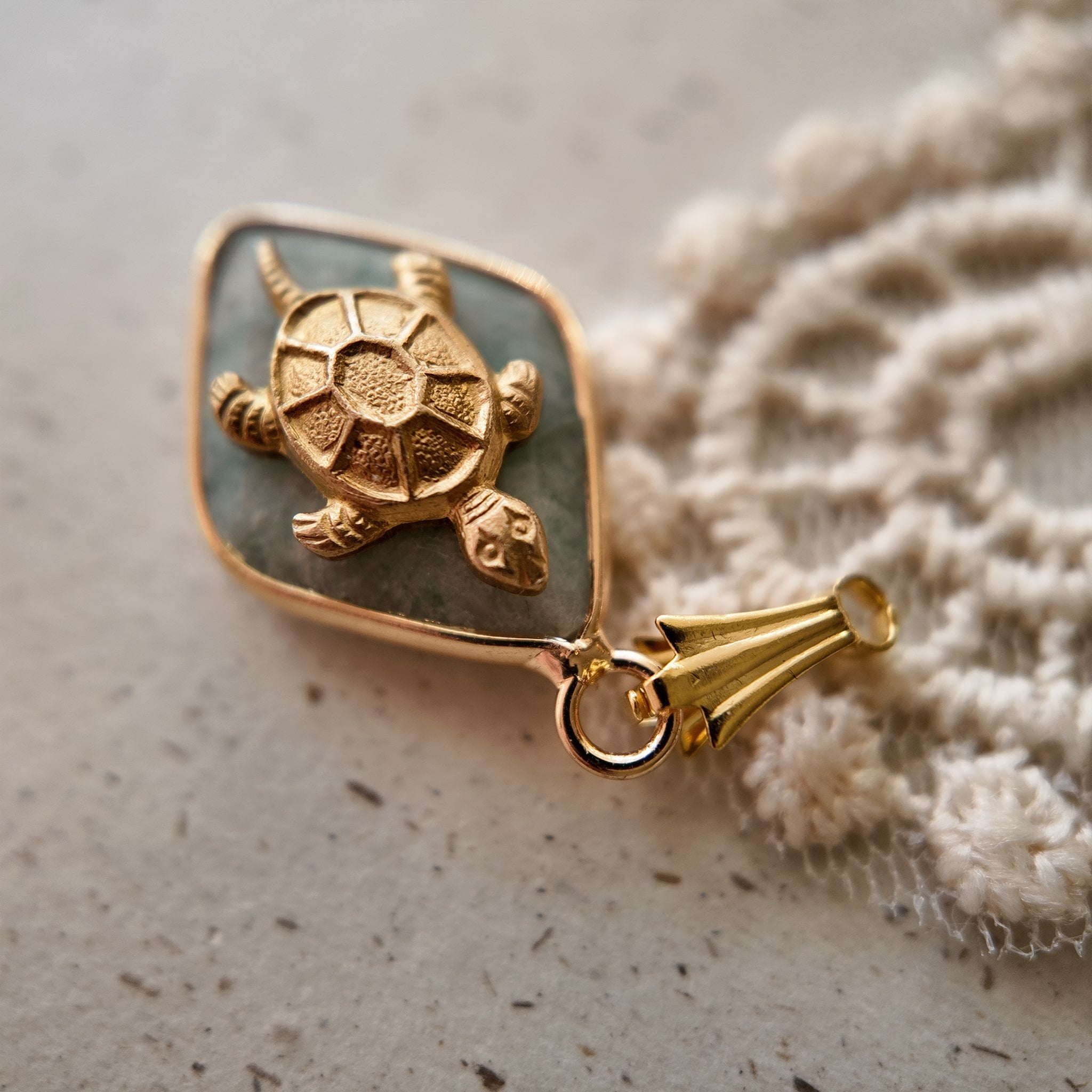 The "Ancient Navigator" turtle charm worn on a chain, showcasing its petite size and its identity as a perfect, minimalist piece of Zen jewelry.