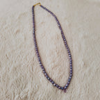 The "Twilight Tear" necklace styled with dried lavender to emphasize its "Twilight Hues" and its identity as a piece of soft, Witchy, ethereal jewelry.
