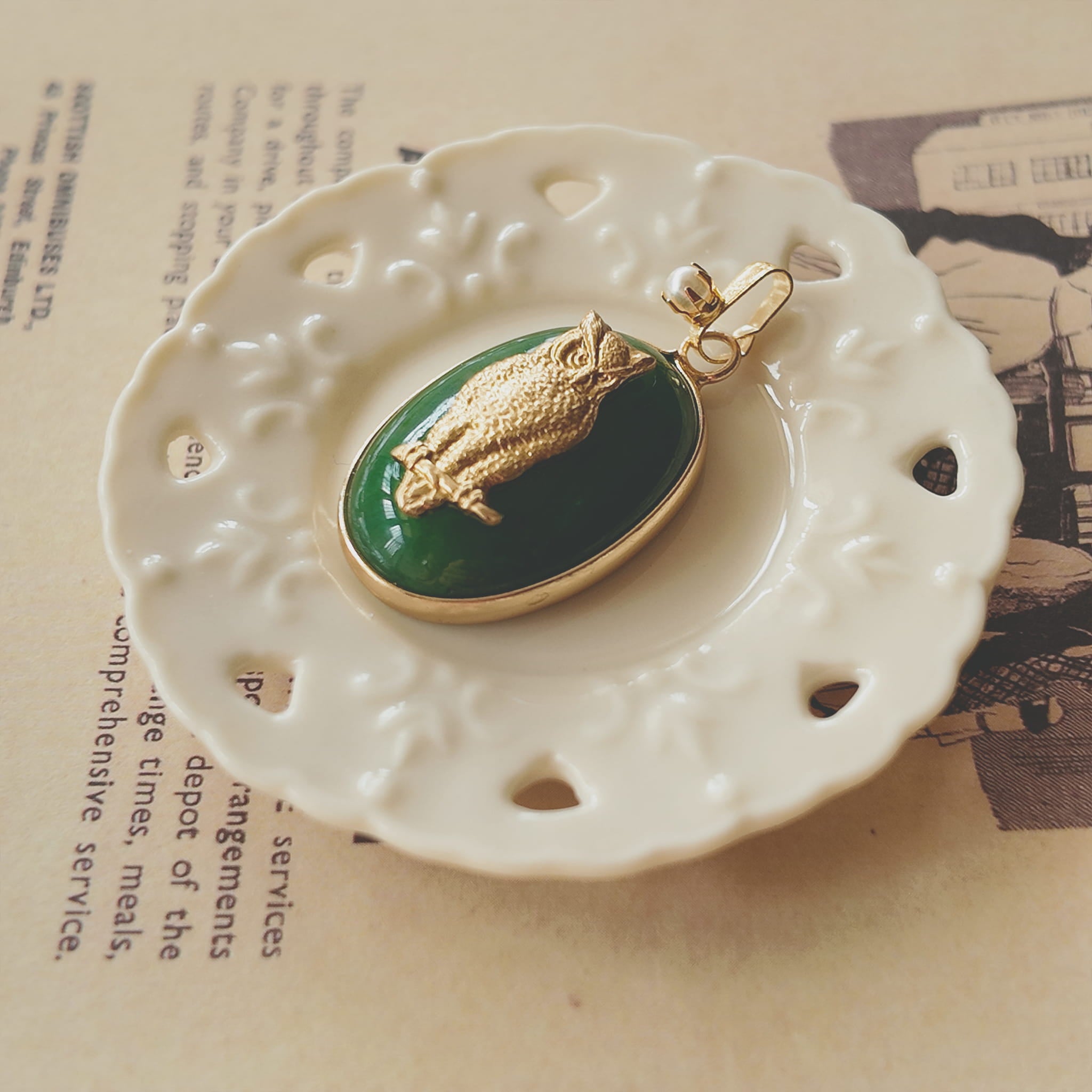 Side profile of the classic oval green jade pendant, showing its solid and grounding feel with gold-plated bezel.