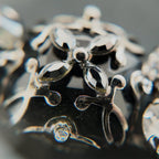 A macro shot detailing the brilliant sparkle of the black diamond crystals and the "poetic decay" of the antiqued filigree on this collectible Sorrelli bracelet.