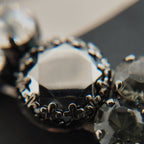 A macro shot detailing the brilliant sparkle of the black diamond crystals and the "poetic decay" of the antiqued filigree on this collectible Sorrelli bracelet.