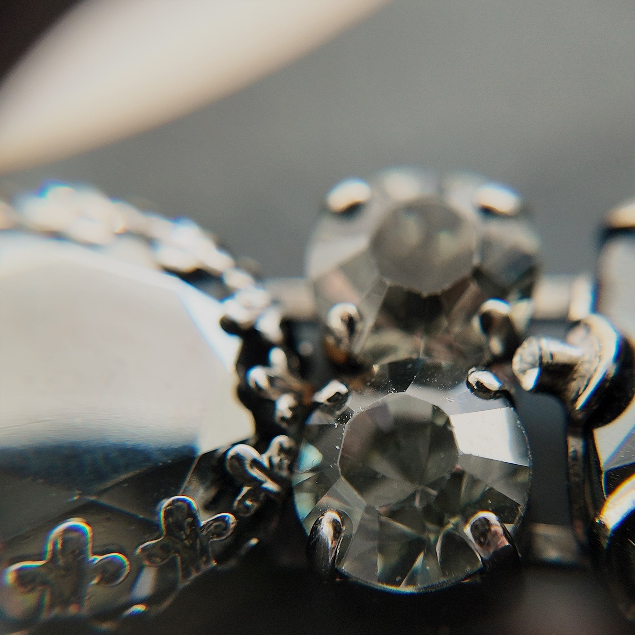 A macro shot detailing the brilliant sparkle of the black diamond crystals and the "poetic decay" of the antiqued filigree on this collectible Sorrelli bracelet.