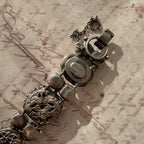 A close-up of the authentic "Sorrelli" signature hang tag on the back of the antiqued silver-tone vintage statement bracelet.