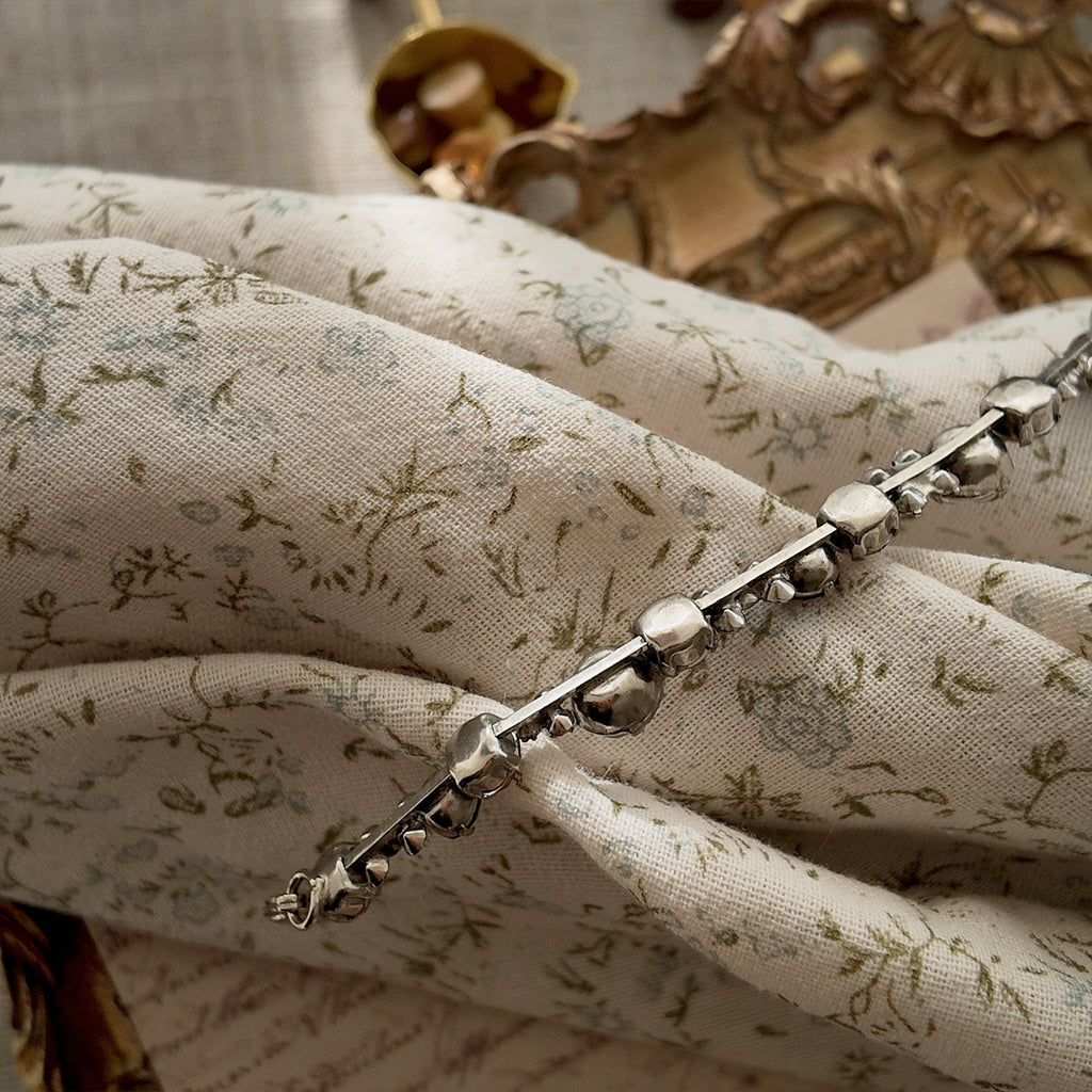 A close-up of the authentic "Sorrelli" signature hang tag on the back of the vintage pink and black crystal bracelet.