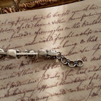 A close-up of the authentic "Sorrelli" signature hang tag on the back of the vintage pink and black crystal bracelet.