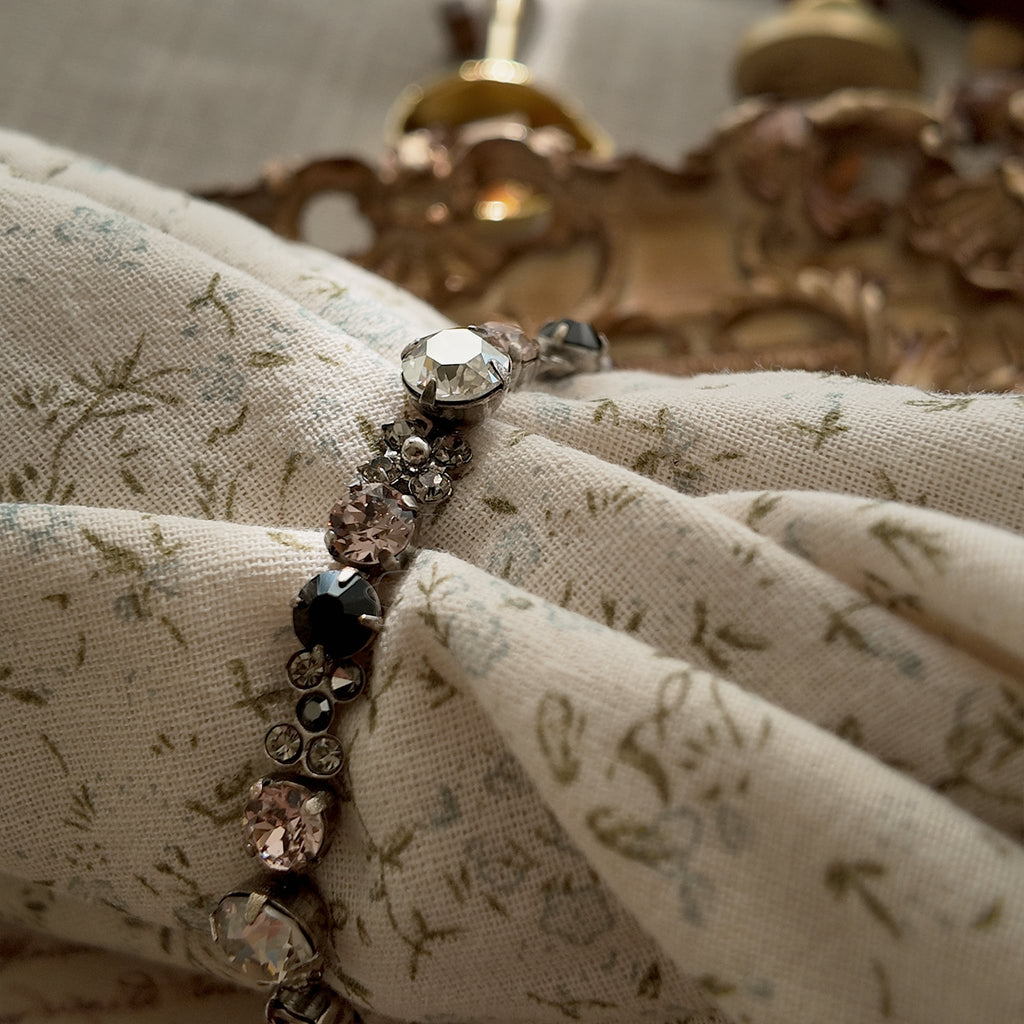 A macro shot detailing the brilliant sparkle of the candy-pink and jet-black Swarovski crystals on this piece of Whimsigoth-style jewelry.