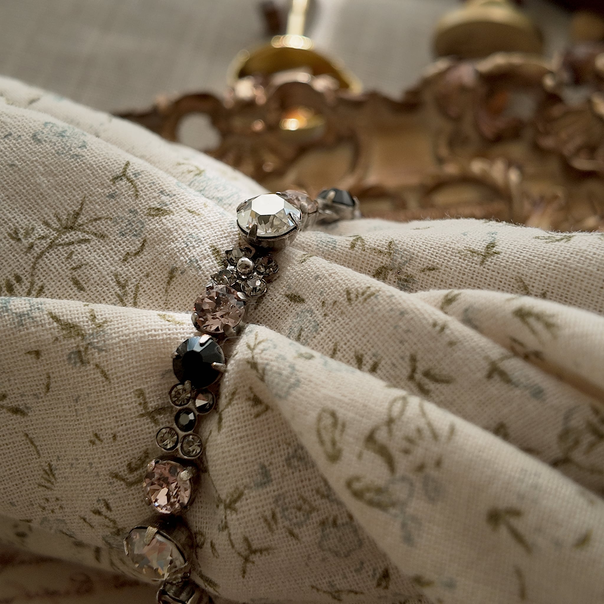 A macro shot detailing the brilliant sparkle of the candy-pink and jet-black Swarovski crystals on this piece of Whimsigoth-style jewelry.