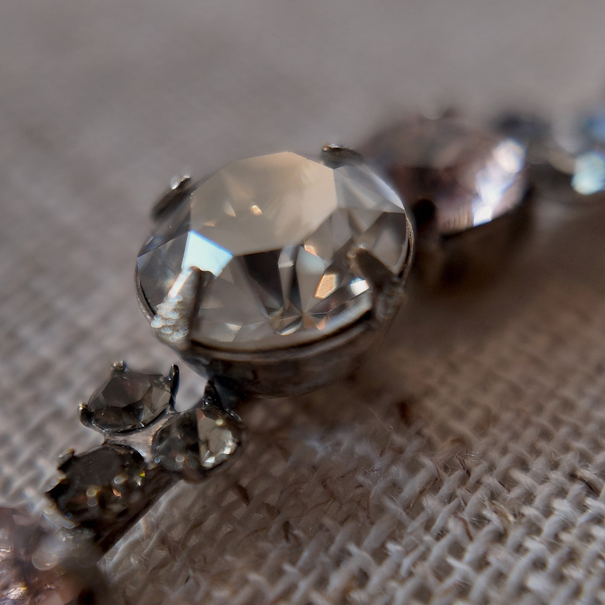 A macro shot detailing the brilliant sparkle of the candy-pink and jet-black Swarovski crystals on this piece of Whimsigoth-style jewelry.