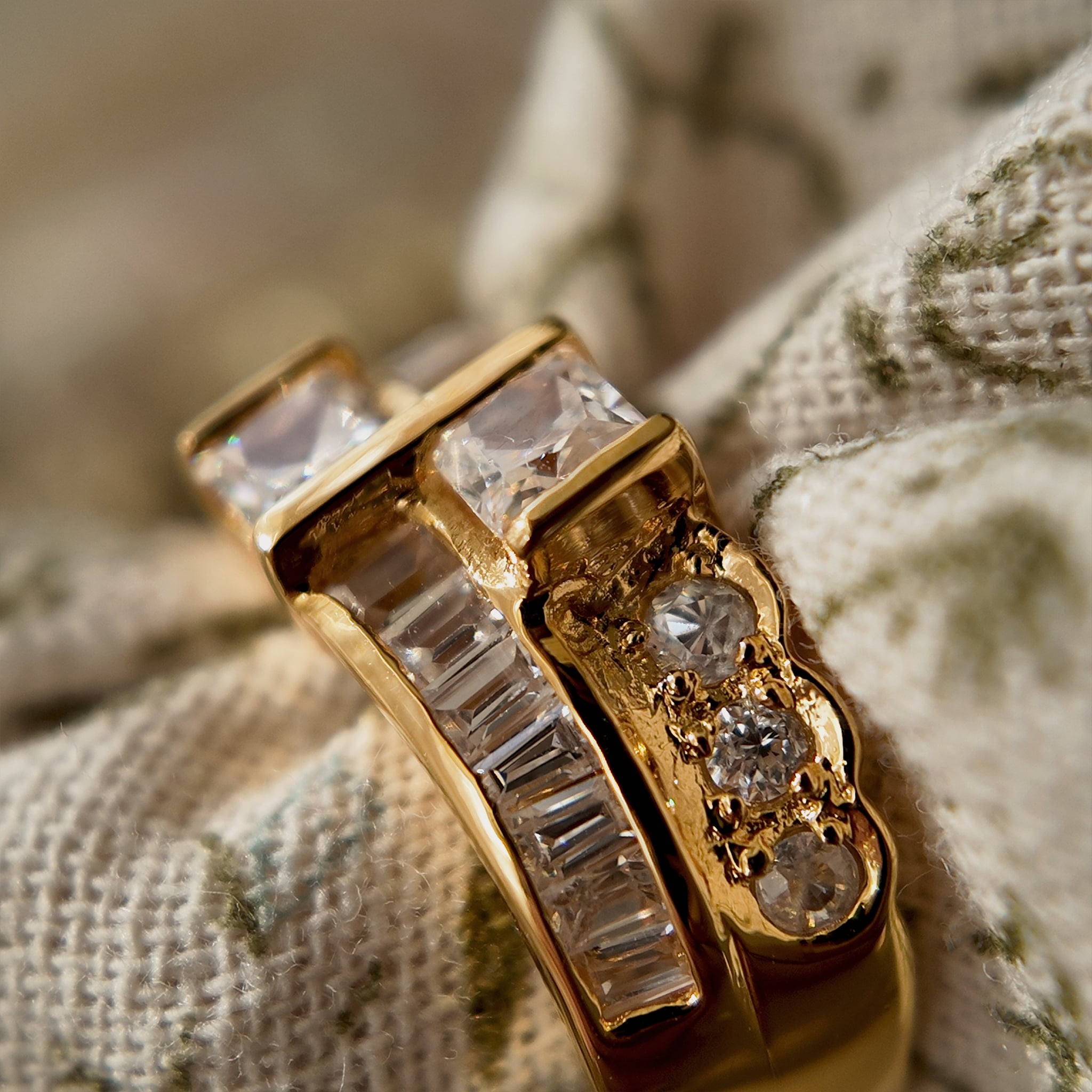A gold ring with A gold ring set with two rows of glass diamonds set through a floral fabric