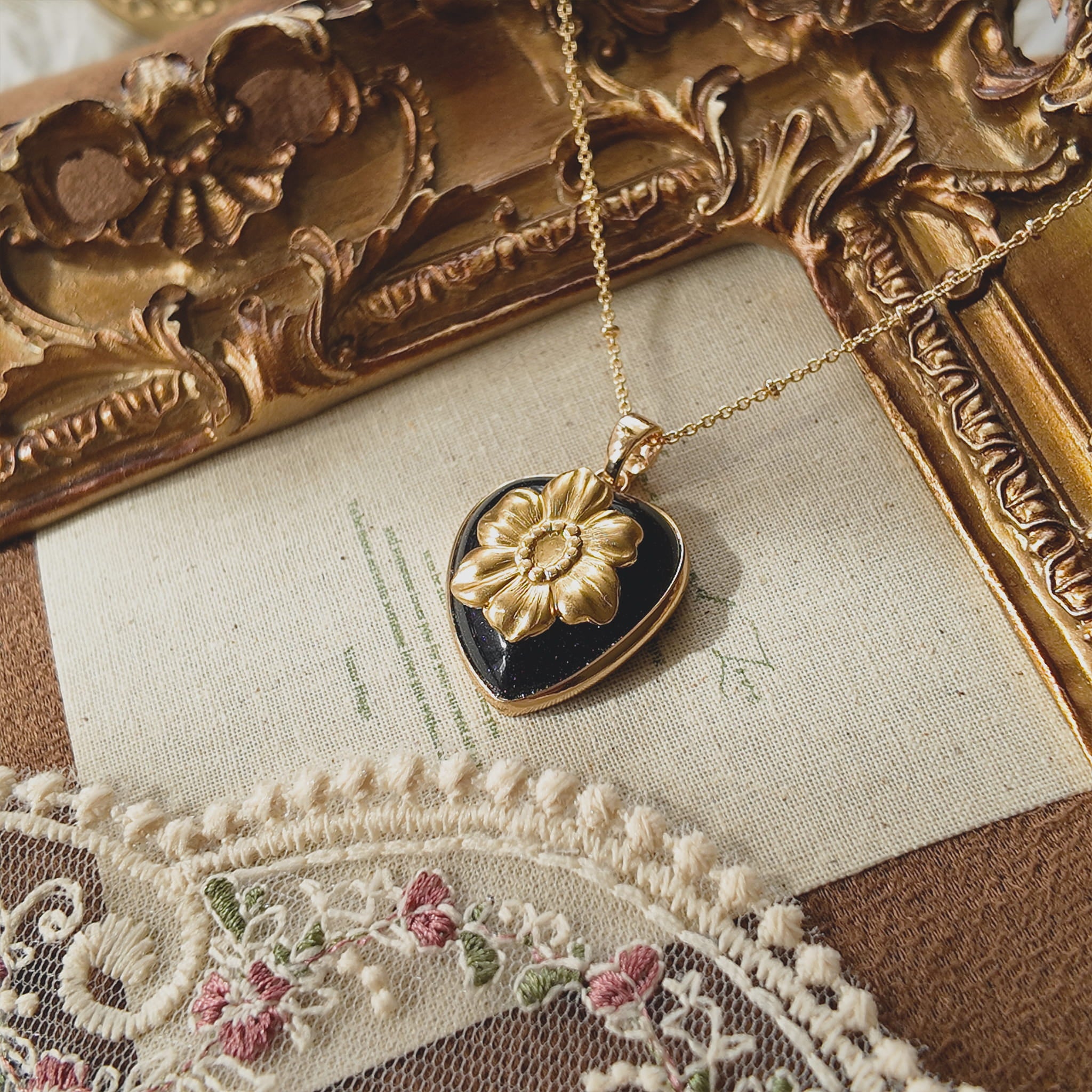 wearing The Bloom in the Dark pendant, showcasing the contrast between the dark stone and gold brass on the neckline.