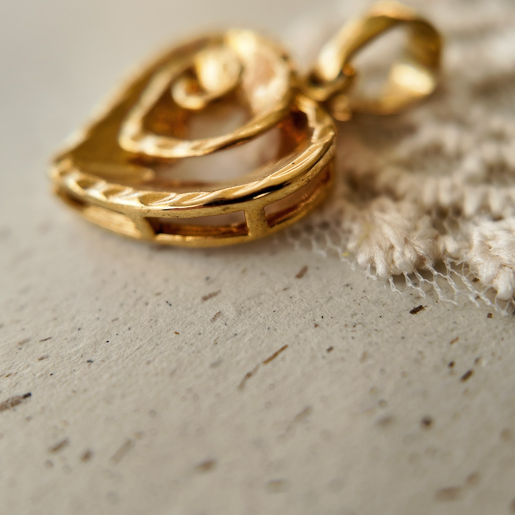 The size of "The Sunset Vortex" small gold pendant compared to show its delicate, potent scale.