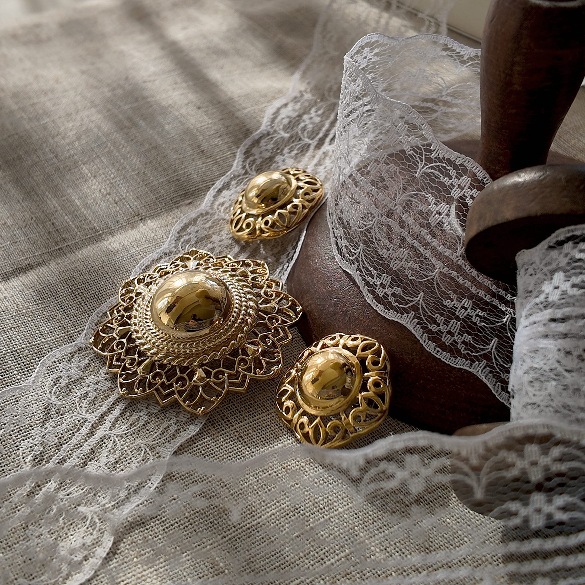 The "Art of Being a Lady," a vintage 1960s Trifari demi-parure, featuring a sculptural gold hat brooch and a pair of matching clip-on earrings.